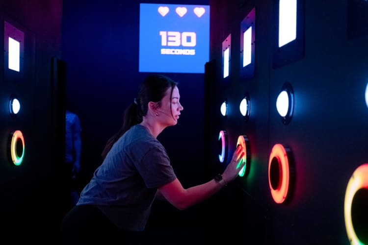 A woman playing an interactive game with neon lights