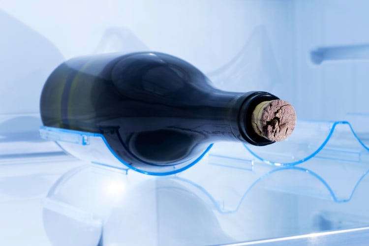 A bottle of wine with a cork in a refrigerator