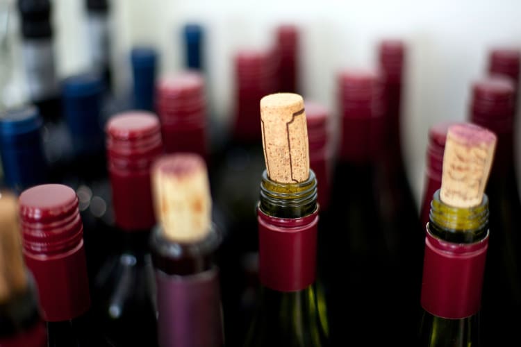 Bottles of opened red wine with corks in them