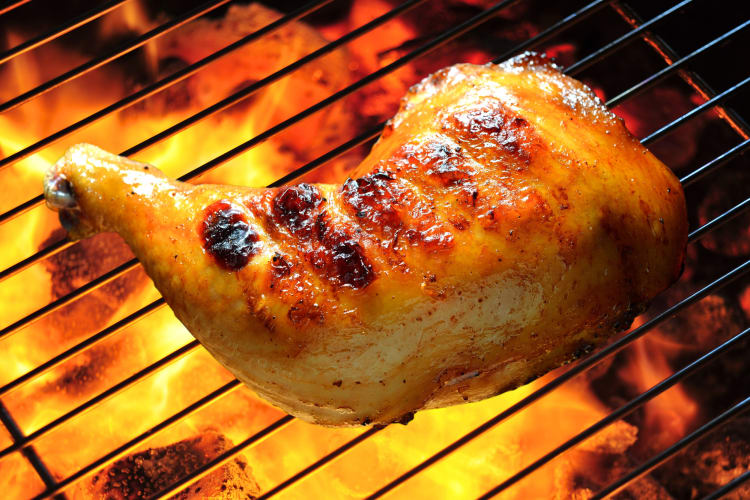 Airline chicken breast being grilled over a fire