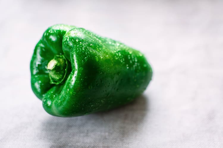 Whole green bell pepper with dew