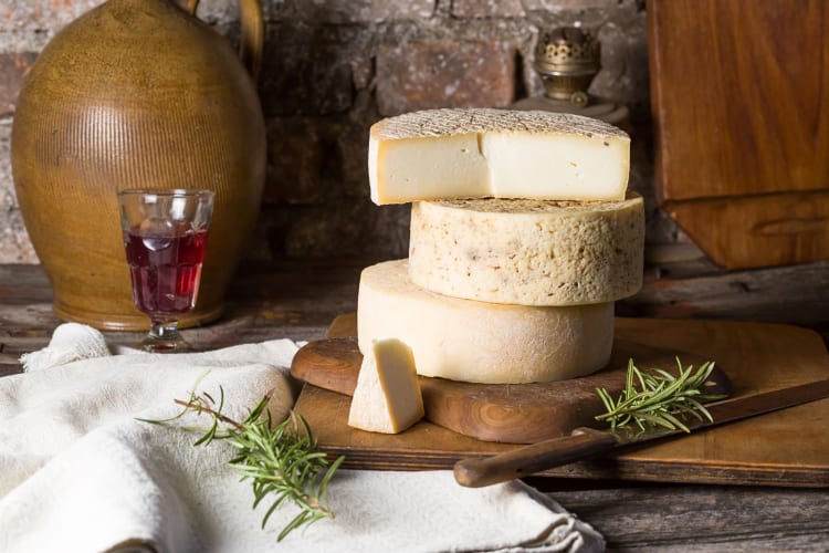 Two and a half wheels of goat cheese stacked on top of each other