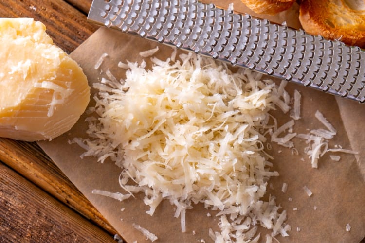 Grated cheese next to a block of cheese