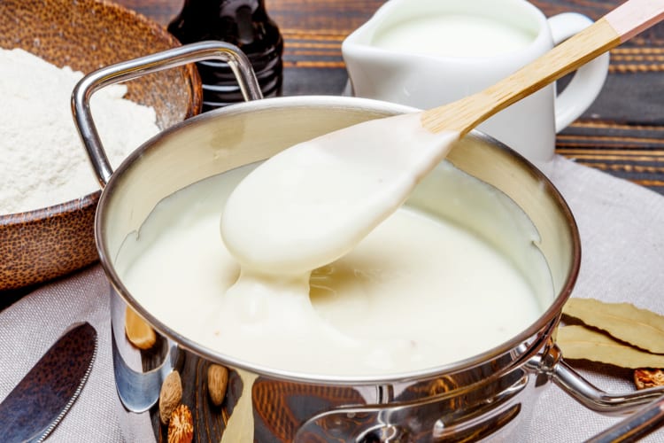A pot of cream sauce next to a jug of cream