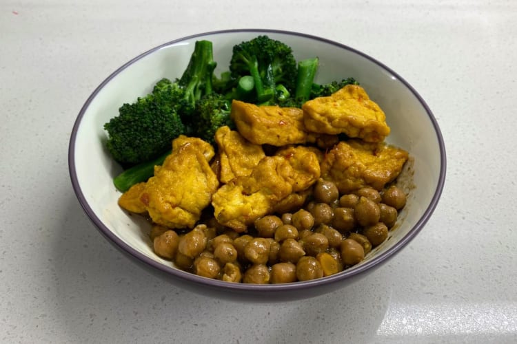 A bowl with chickpeas, broccoli, and puffed tofu