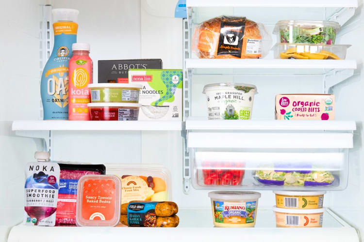 An open fridge with colorful packaged products on the shelves