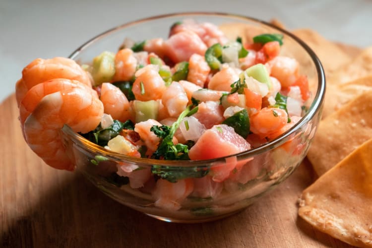 Prawn ceviche in a bowl next to tortilla chips