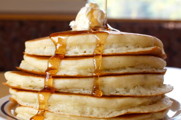 A stack of pancakes with syrup and butter