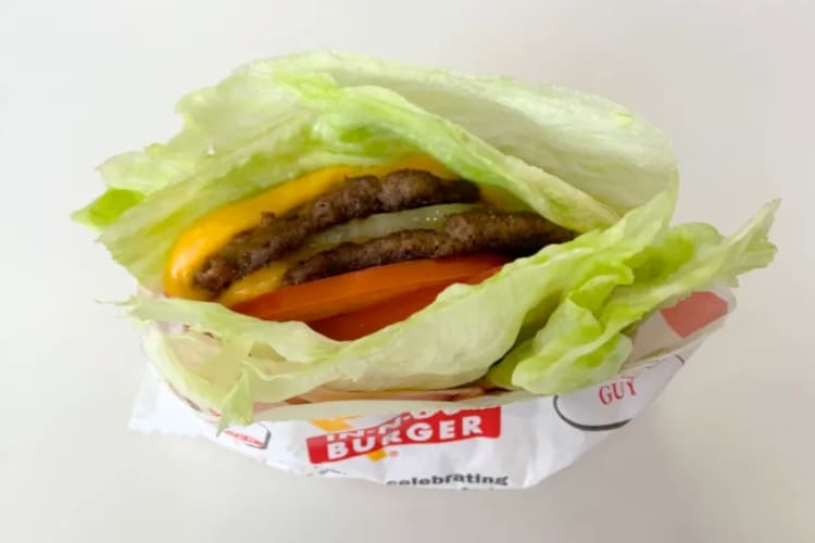 Beef patties and burger toppings in lettuce leaves