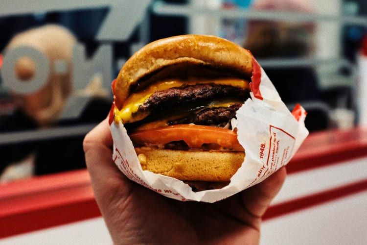 A person holding an In-N-Out burger