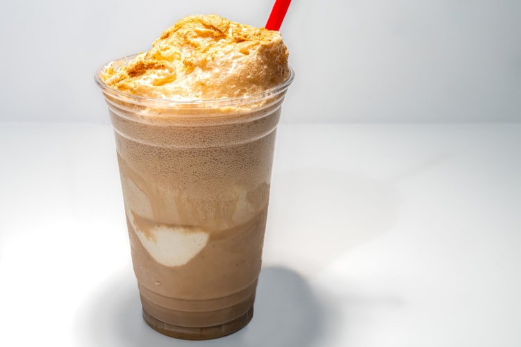 A root beer float in a plastic cup