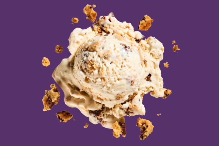 A scoop of cookie dough ice cream on a purple background