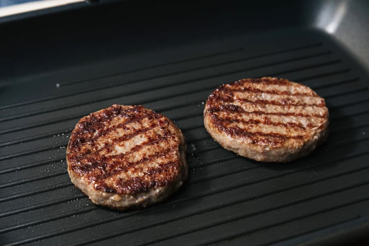 Two burger patties being grilled