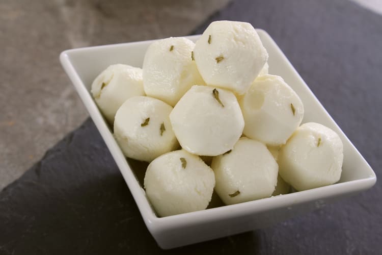 Balls of goat cheese stacked in a bowl