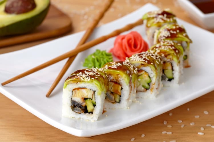 A dragon roll with avocado, fish and unagi sauce