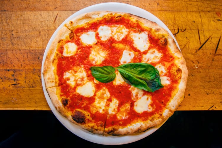 A pizza with tomato, mozzarella and basil