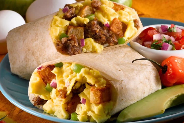 Breakfast burrito cut in half with relish on the side