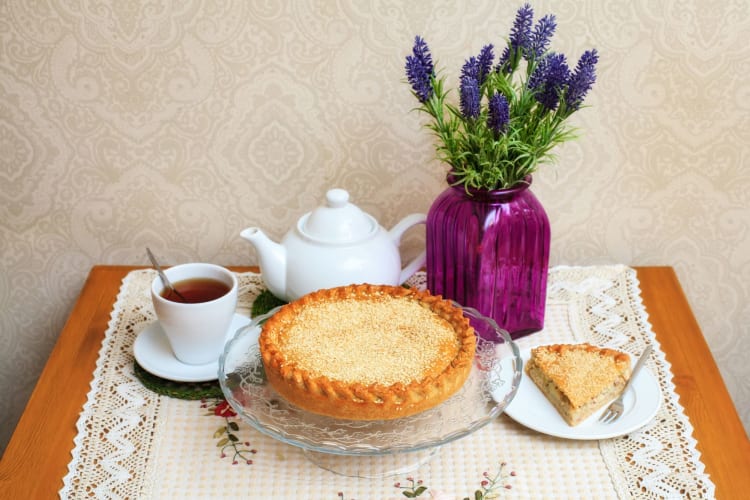 Meat pie with sesame, teapot, cup of tea