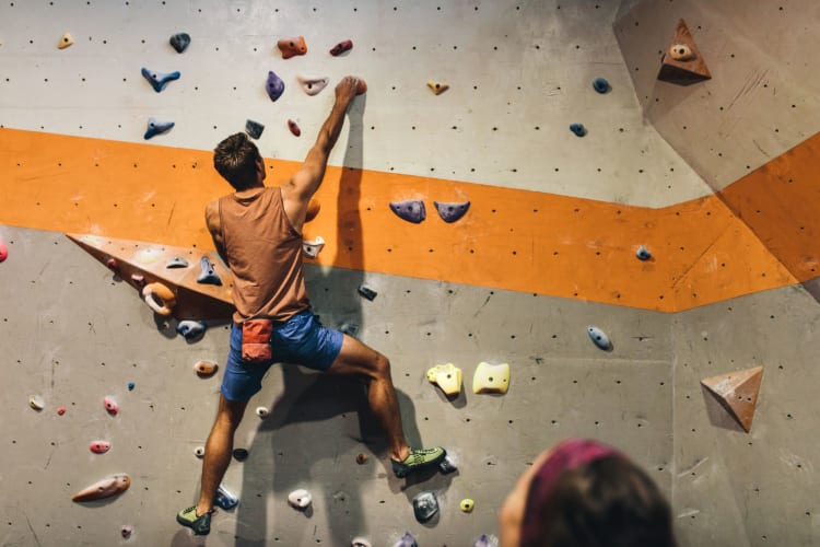 man bouldering in indoor gym
