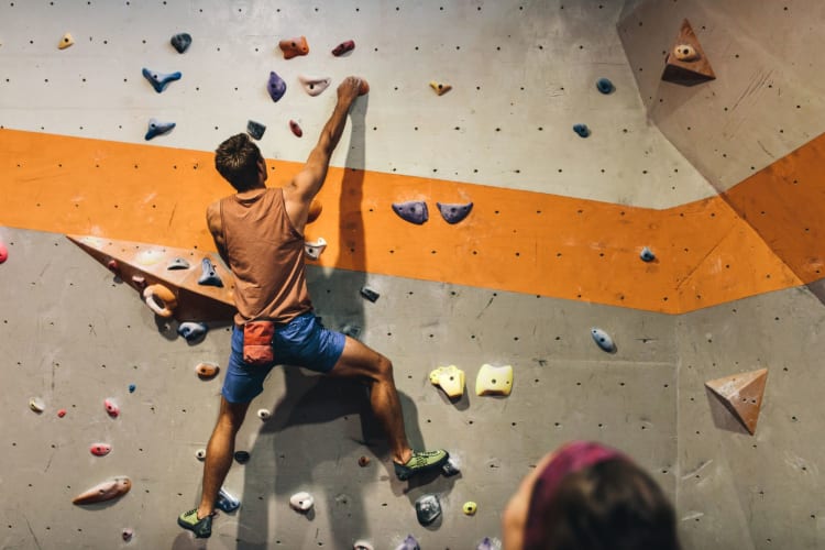 man bouldering in indoor gym