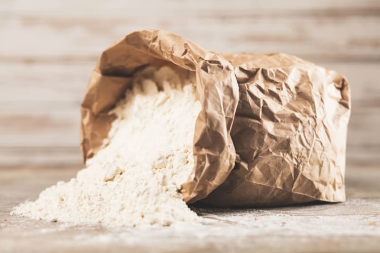 bag of flour on wooden background