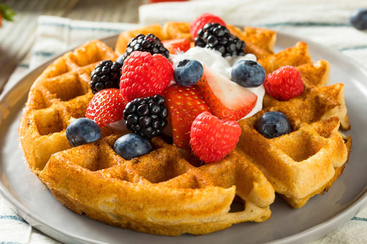 Belgian waffle with cream and an assortment of berries on top