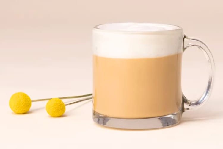 A glass mug with a milky coffee drink
