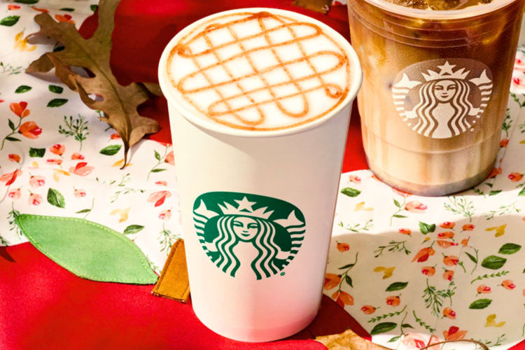 A Starbucks cup with a beverage with a caramel drizzle