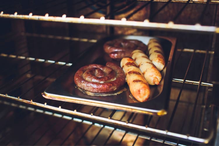 Sausages cooking in an oven.
