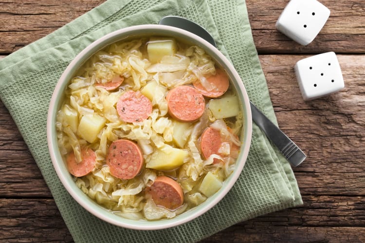 A soup or stew with slices of sausage.
