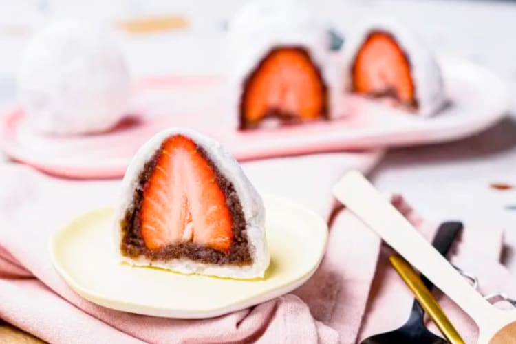 Mochi with whole strawberries on a plate
