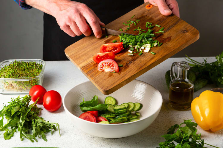 Close-up shot of person making the best fast food salad with an assortment of vegetables