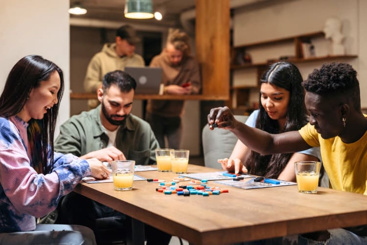 Four people playing a board game in a café