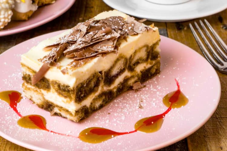 A portion of tiramisu on a pink plate
