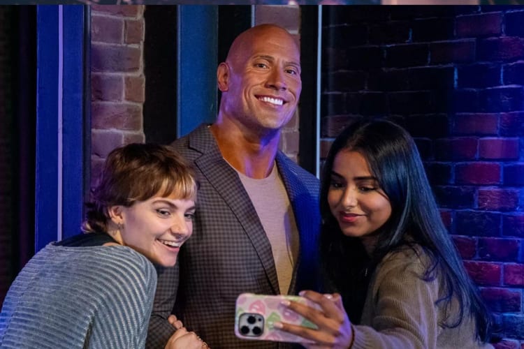 Visitors at Madame Tussauds pose for a selfie with a wax-work model of Dwayne Johnson. 