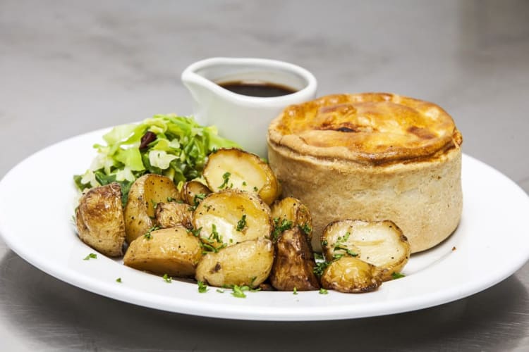 A delicious pie with herb-garnished potatoes, cabbage and gravy.