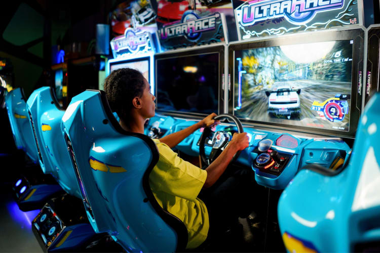 A teenager playing a game in an arcade