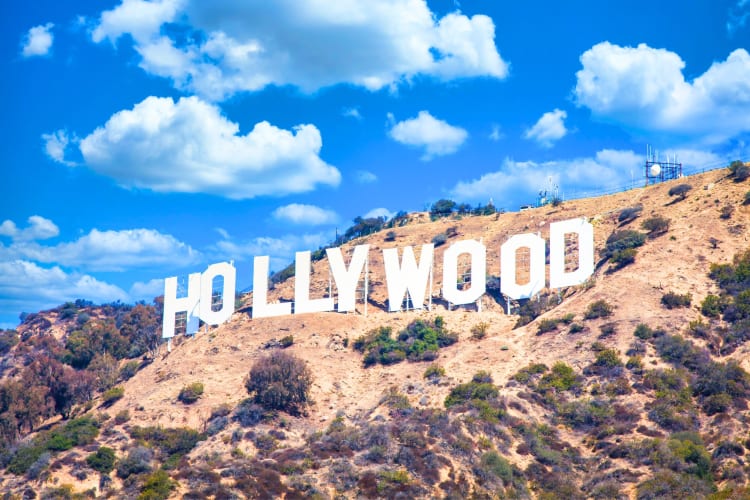 The Hollywood Sign on a hill under a blue sky