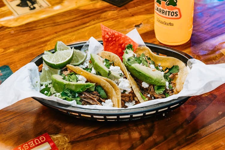 Tacos with meat, cheese and avocado from Los Vaqueros