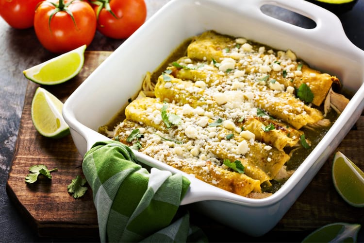 A dish with enchiladas with green sauce