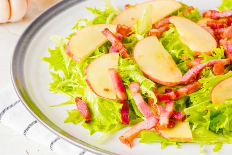 Lettuce on a plate with apple slices and bacon