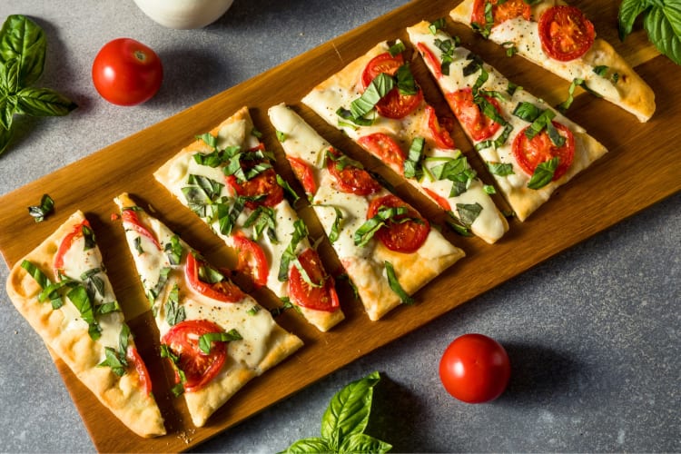 A flatbread pizza with mozzarella, tomato and basil