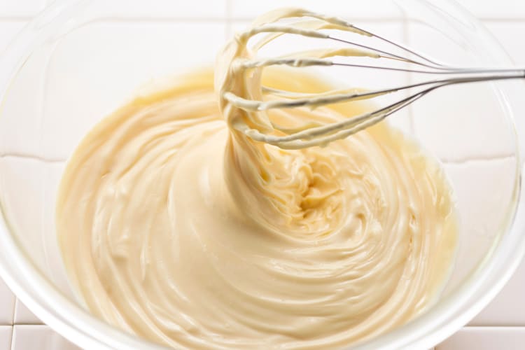 Mayonnaise in a bowl with a whisker in it