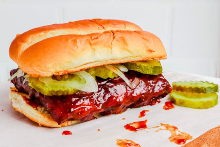 A rib sandwich with onions and pickles
