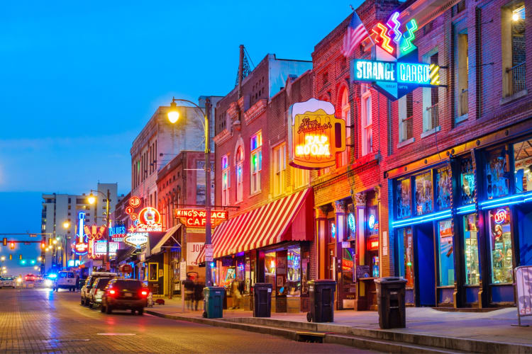 A street at night illuminated by neon signs
