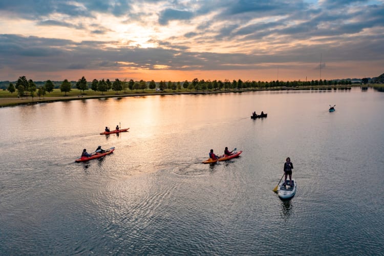 People kayaking on a lake at sunset