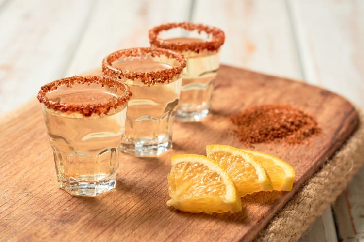 Shots of tequila with spice mix on the rim