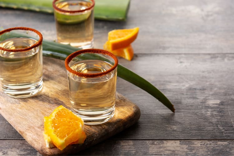 Shot glasses with tequila and orange