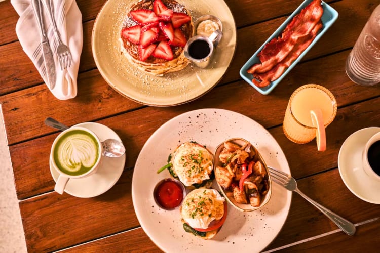 An overhead shot of breakfast dishes and drinks on a table