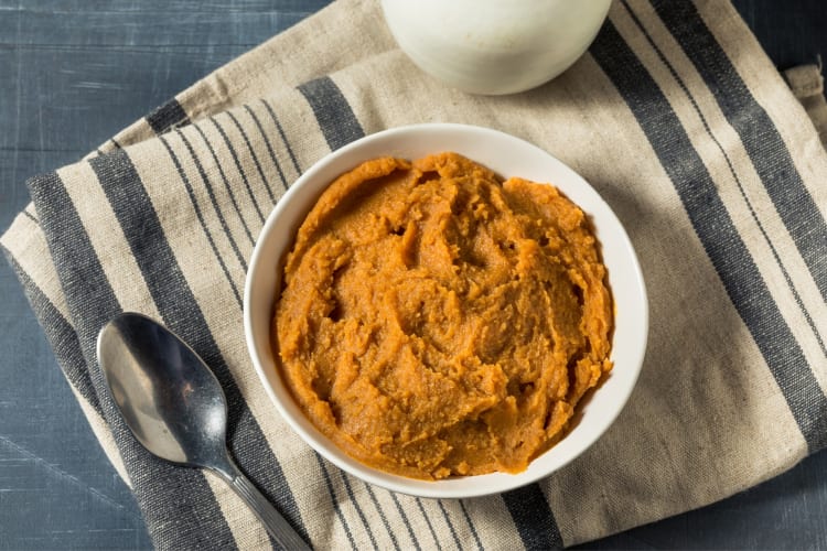 Miso paste in a bowl on a cloth next to a spoon